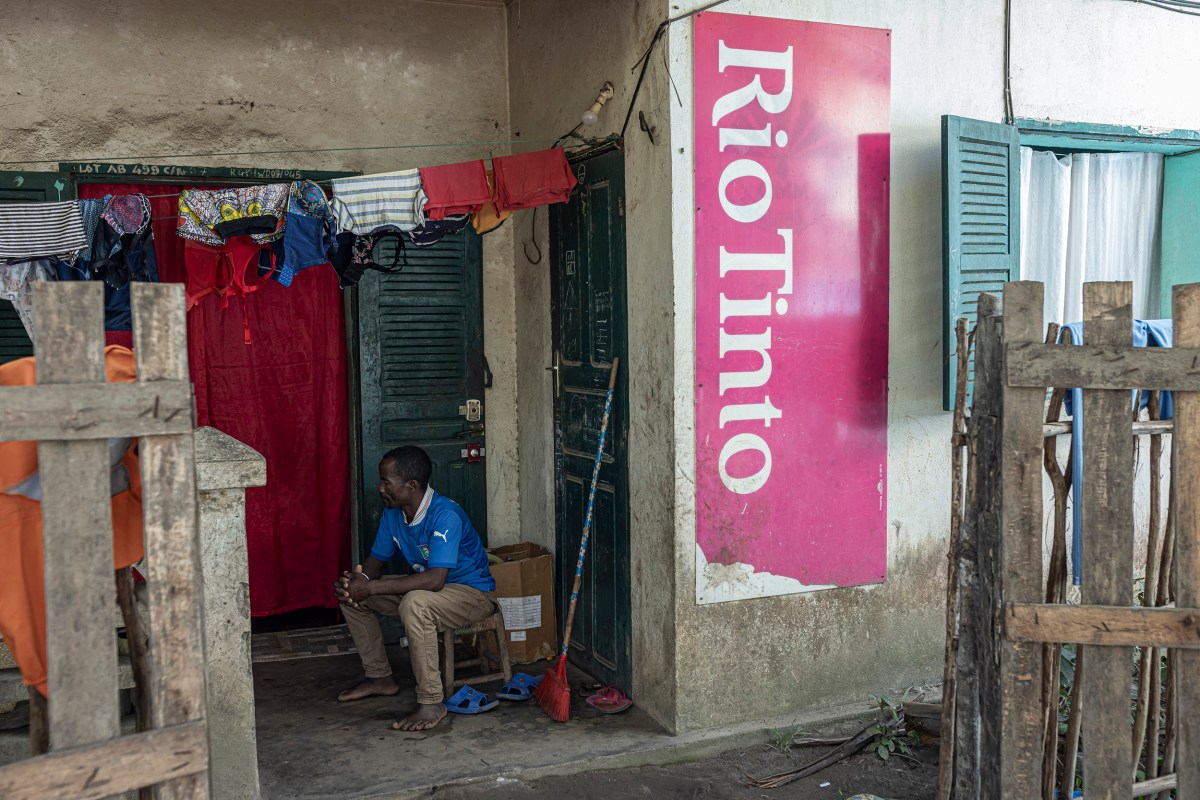 A man stands next to a Rio Tinto sign at Ampasy Nahampoana health center in Fort-Dauphin, Madagascar, on July 10, 2023.