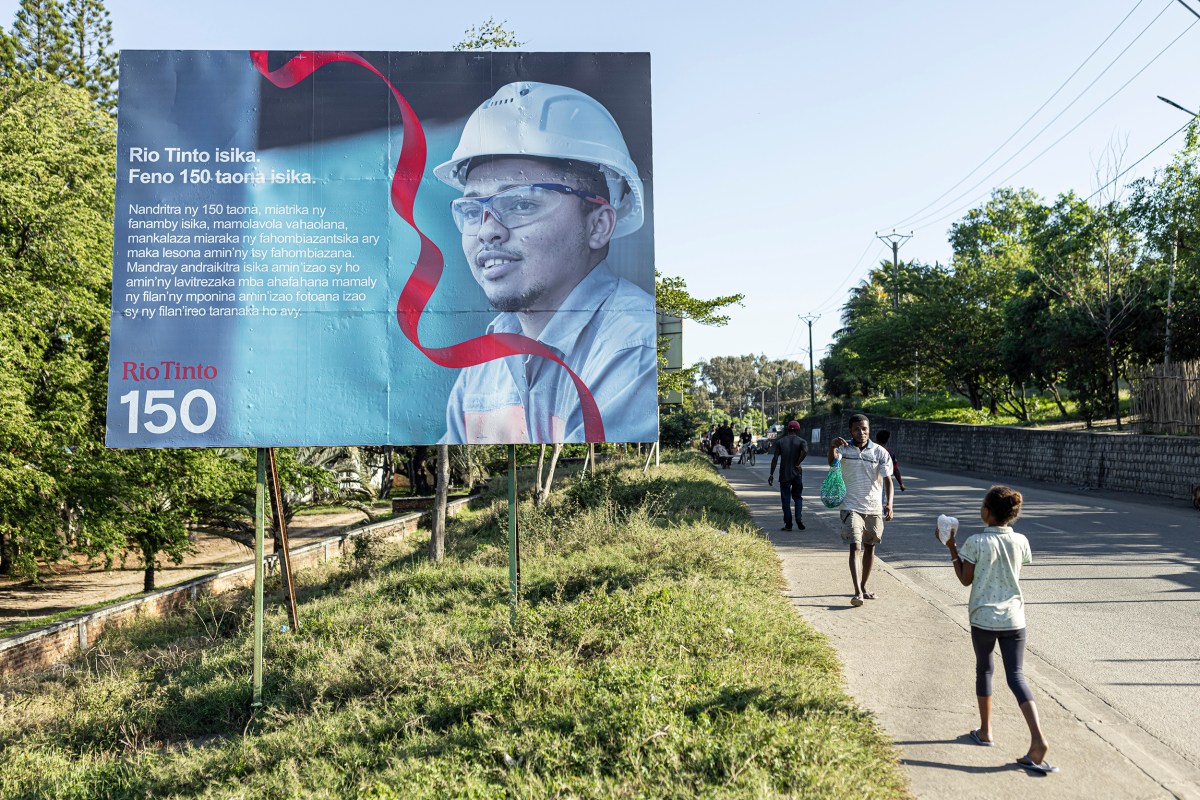 People walk past a sign celebrating Rio Tinto´s 150 years in Fort-Dauphin, Madagascar, on July 8, 2023.