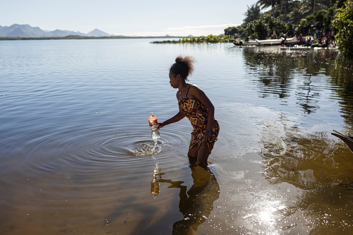 Razafimandimby Maurella, 24, collects water from Lake Larinano in Fort-Dauphin, Madagascar, on July 9, 2023. People living near the lake use the water for everything, from washing clothes to drinking.