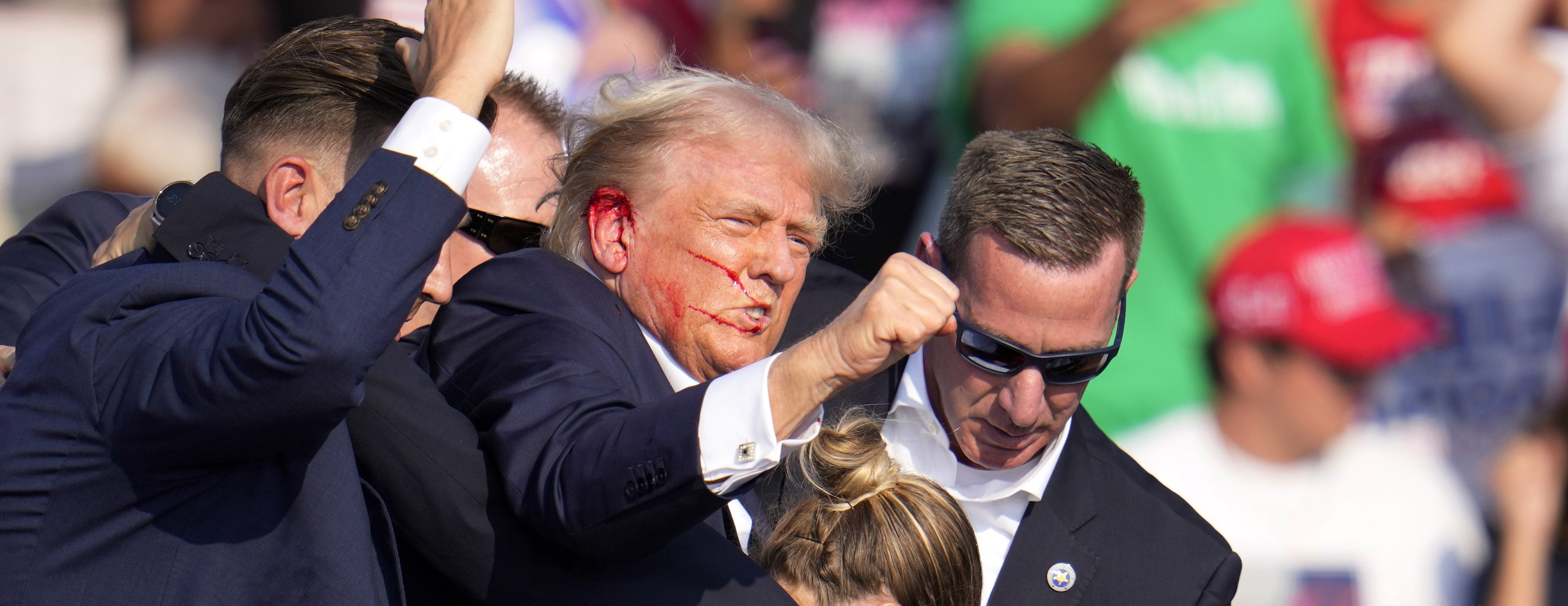 Republican presidential candidate former President Donald Trump is helped off the stage by U.S. Secret Service at a campaign event in Butler, Pa., on Saturday, July 13, 2024.