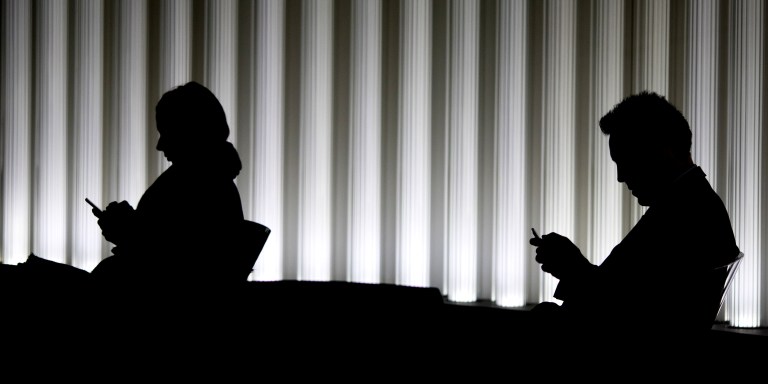 City workers use smartphones inside an office in the City of London, U.K., on Monday. Oct. 30, 2017. The Bank of England may raise interest rates this week for the first time in more than a decade, but that wont be enough to buoy the pound, strategists say. Photographer: Jason Alden/Bloomberg via Getty Images