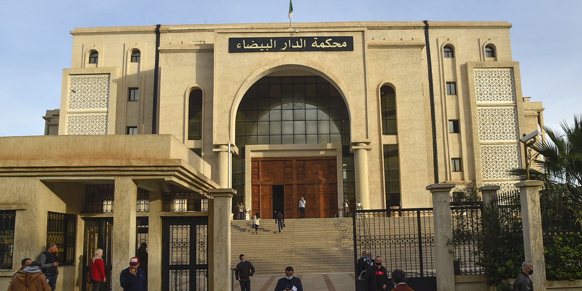 People gather in front of the  Algerian Dar Al-Baida tribunal in the capital Algiers, where the trial of men accused of the murder of Herve Gourdel, a French mountain guide who was decapitated by jihadists almost six years ago is taking place, on February 4, 2021. - Fourteen people are being prosecuted: 8 suspected kidnappers, the 5 Algerian hosts and companions of the Frenchman, as well as a man, Farjallah Amara, whose link to this case is not specified, according to a court document consulted by AFP. (Photo by RYAD KRAMDI / AFP) (Photo by RYAD KRAMDI/AFP via Getty Images)