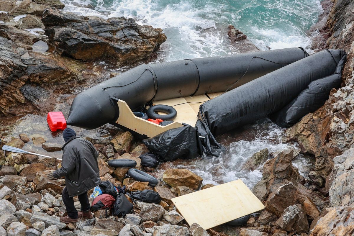 A man stands next to a rubber boat in Thermi on the Greek island of Lesbos on February 7, 2023.