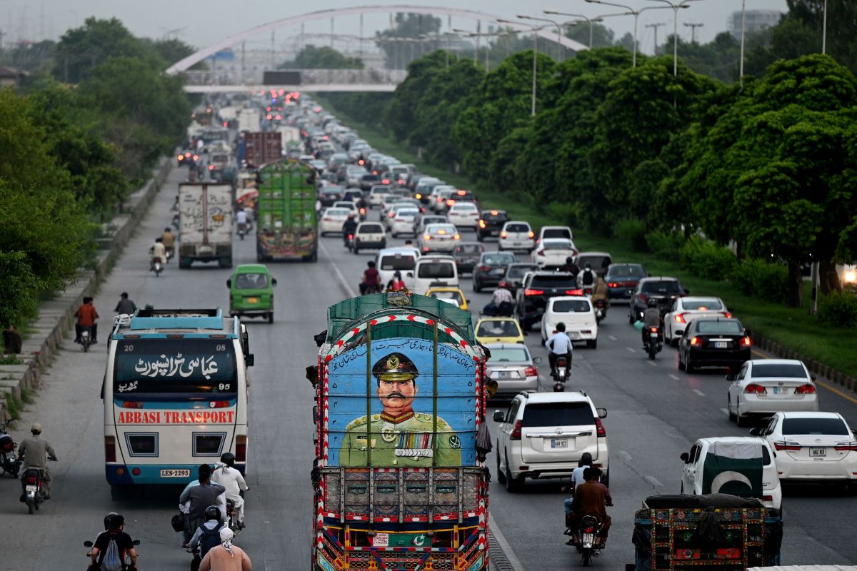 Commuters ride past a truck painted with a portrait of country's Army Chief General Syed Asim Munir, in Islamabad on August 16, 2023. (Photo by Farooq NAEEM / AFP) (Photo by FAROOQ NAEEM/AFP via Getty Images)