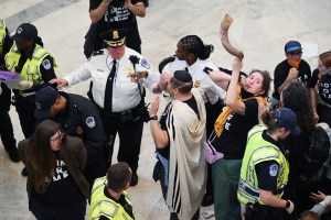 WASHINGTON, DC - OCTOBER 18: Police personnel detain demonstrators as they gather in the rotunda in the Cannon House Office Building during a Jewish Voice for Peace event looking for a ceasefire in the Israel and Gaza conflict on Wednesday October 18, 2023 in Washington, DC. (Photo by Matt McClain/The Washington Post via Getty Images)